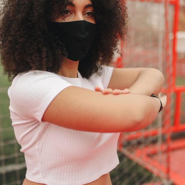 Person stretching energetically outdoors, symbolizing vitality and health.